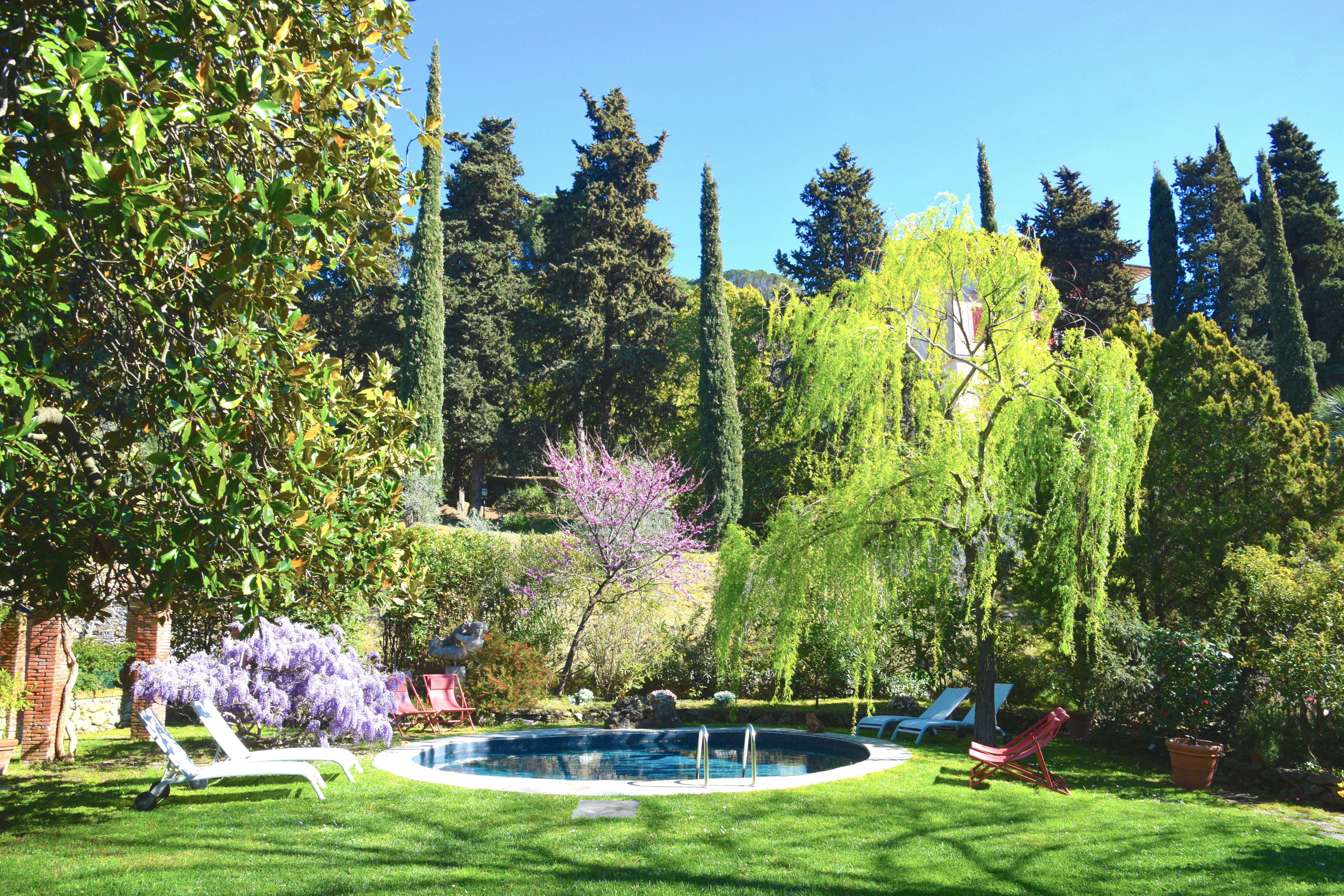 Piscina del Relais Rantegosa con glicine viola in fiore
